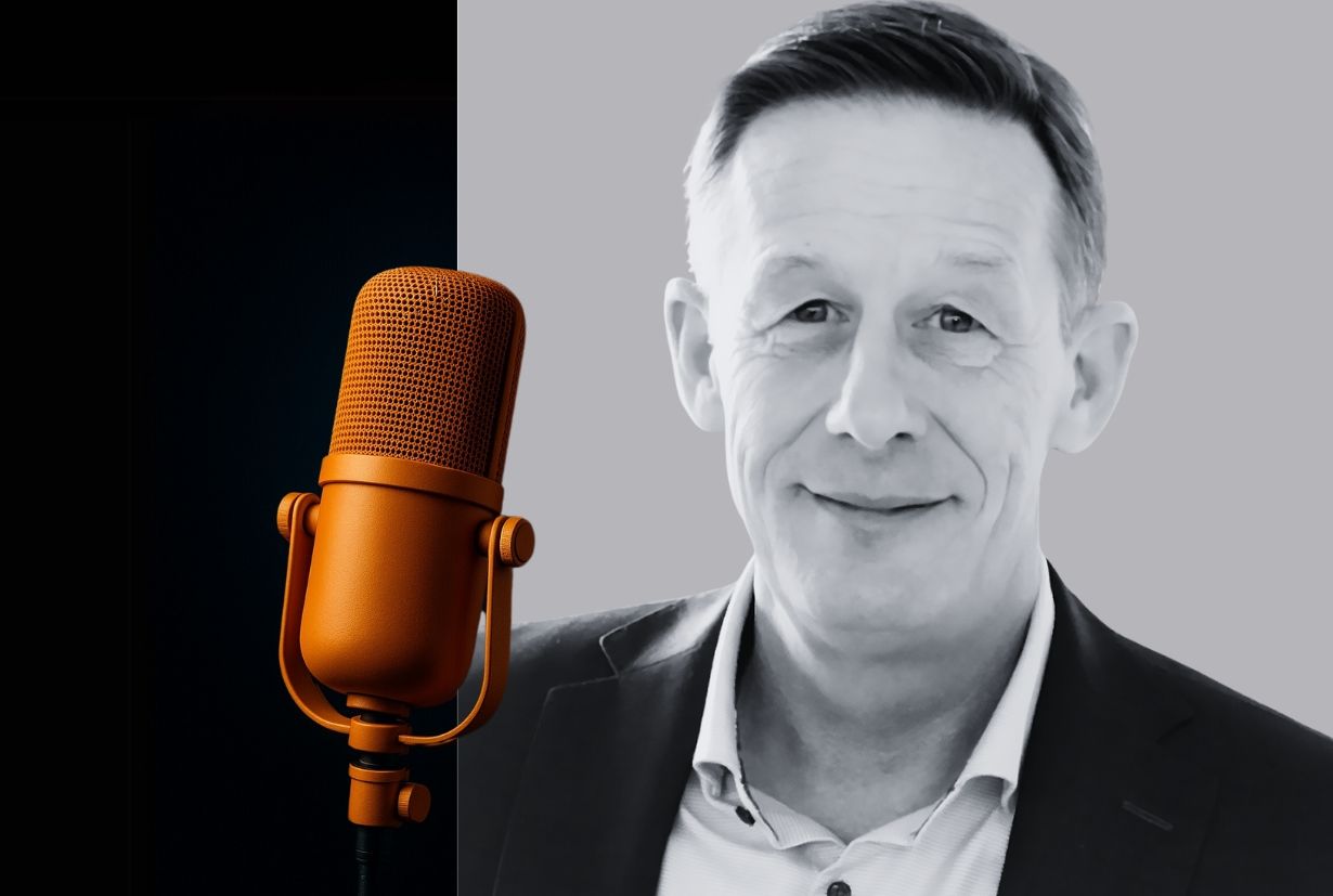 Porträt von Dr. Roger Huber, Arbeits- und Organisationspsychologe, neben einem goldfarbenen Mikrofon – Symbolbild für das Interview im Coopers Executive Blog.