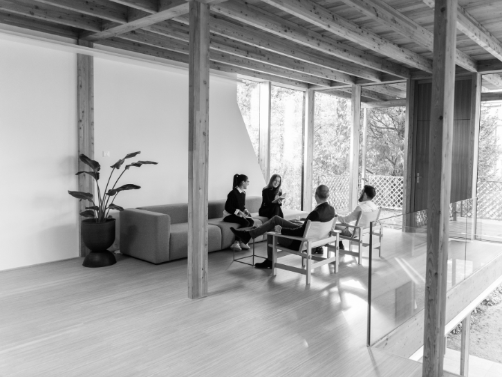 Services | Coopers Executive Four people sit on a sofa and chairs and talk to each other.