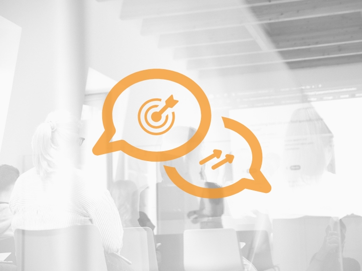 Icon two speech bubbles, bright meeting room in the background.